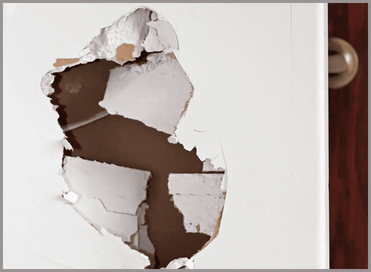 Hole in white drywall with exposed interior.