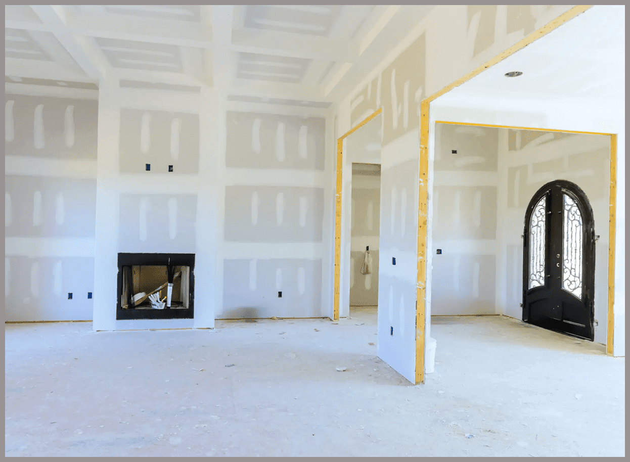 Unfinished room with drywall and arched door.