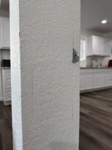 White textured wall with visible cracks.