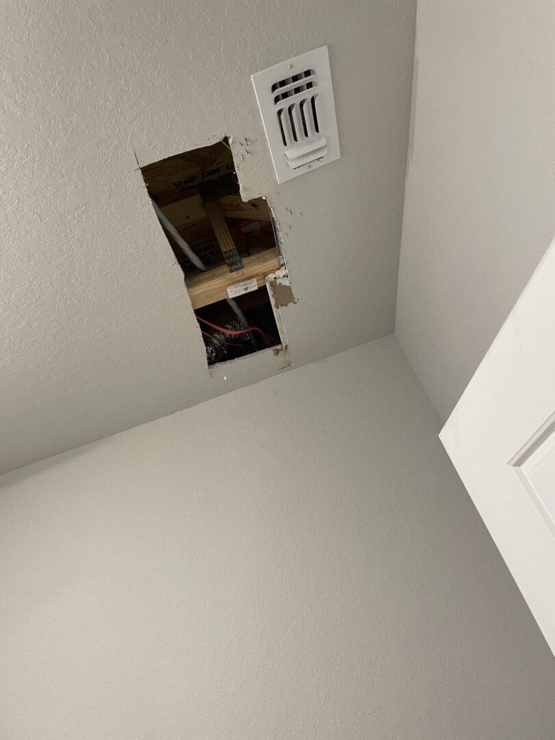 Ceiling with hole and visible ductwork.