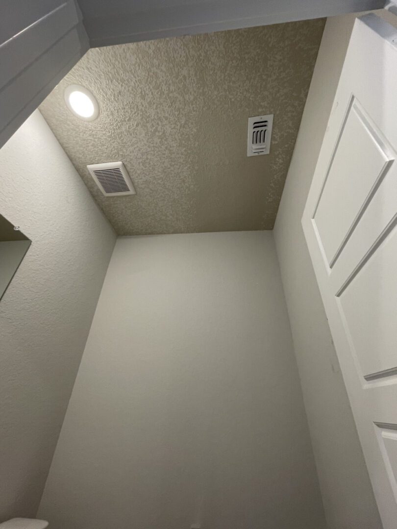 Ceiling with vents and recessed light.