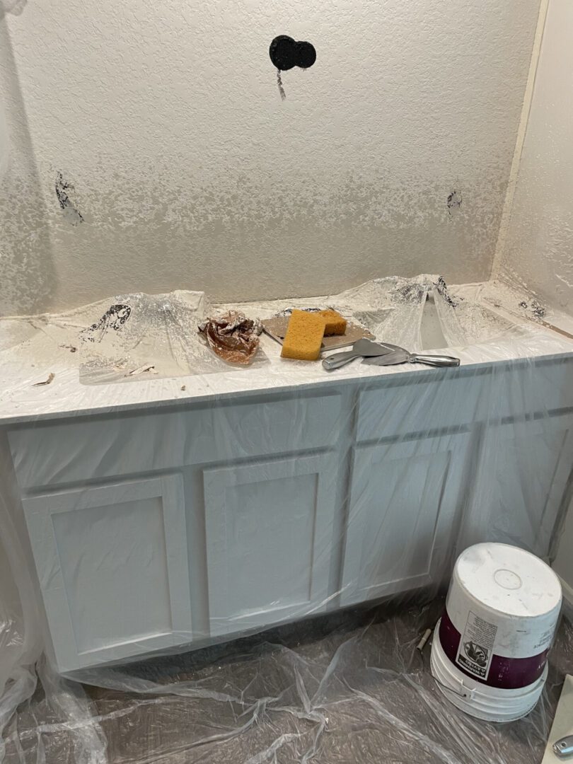 Bathroom renovation with tools and paint supplies.