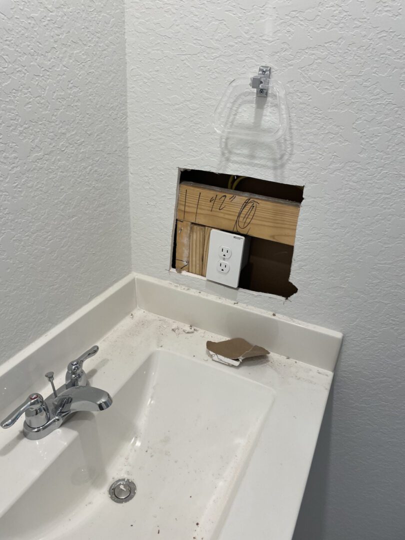 Bathroom sink with exposed wall socket.