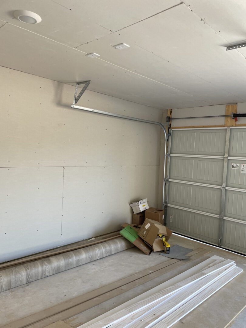 Unfinished garage with construction materials inside.