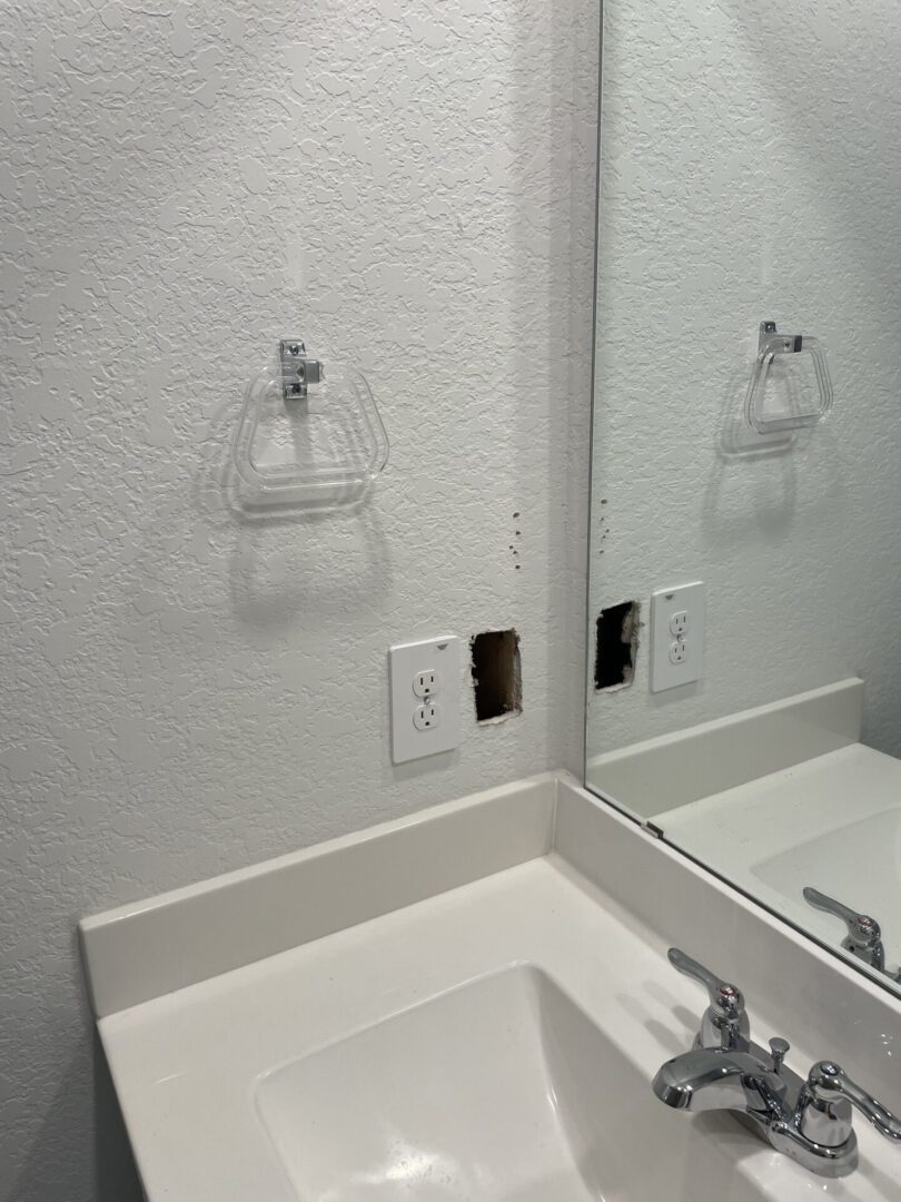 Bathroom sink with wall socket hole.