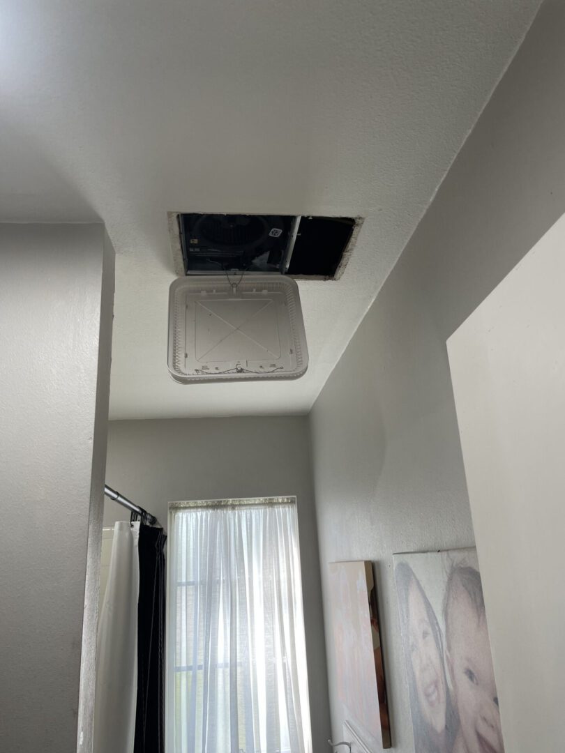 Ceiling vent repair with open panel.
