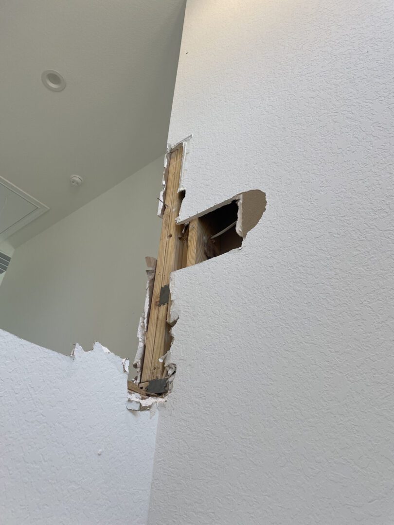 Wall with exposed wooden beams and damage.