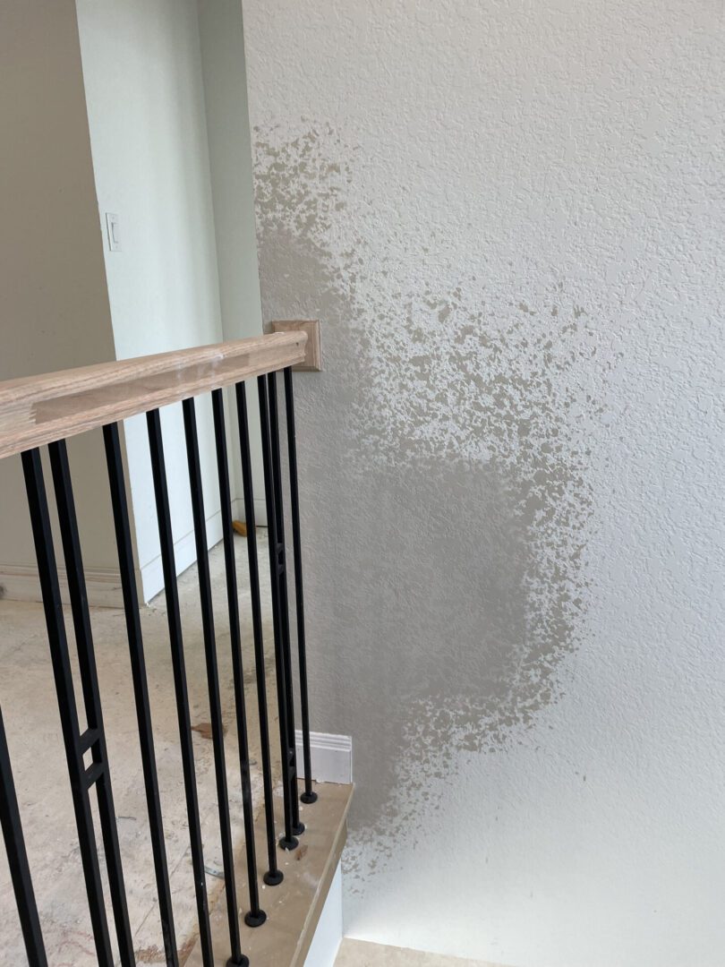 Wall with mold near staircase railing.
