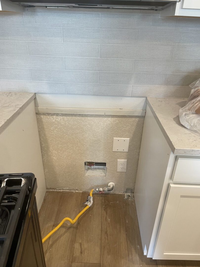 Kitchen stove area with gas line visible.