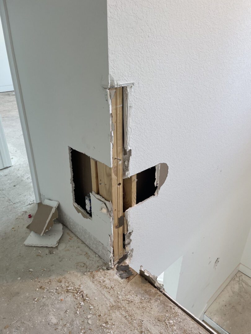Damaged wall with exposed wooden beams.