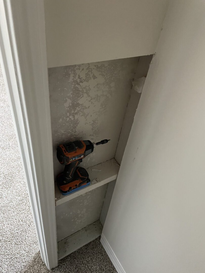 Drill on a small, empty wall shelf.