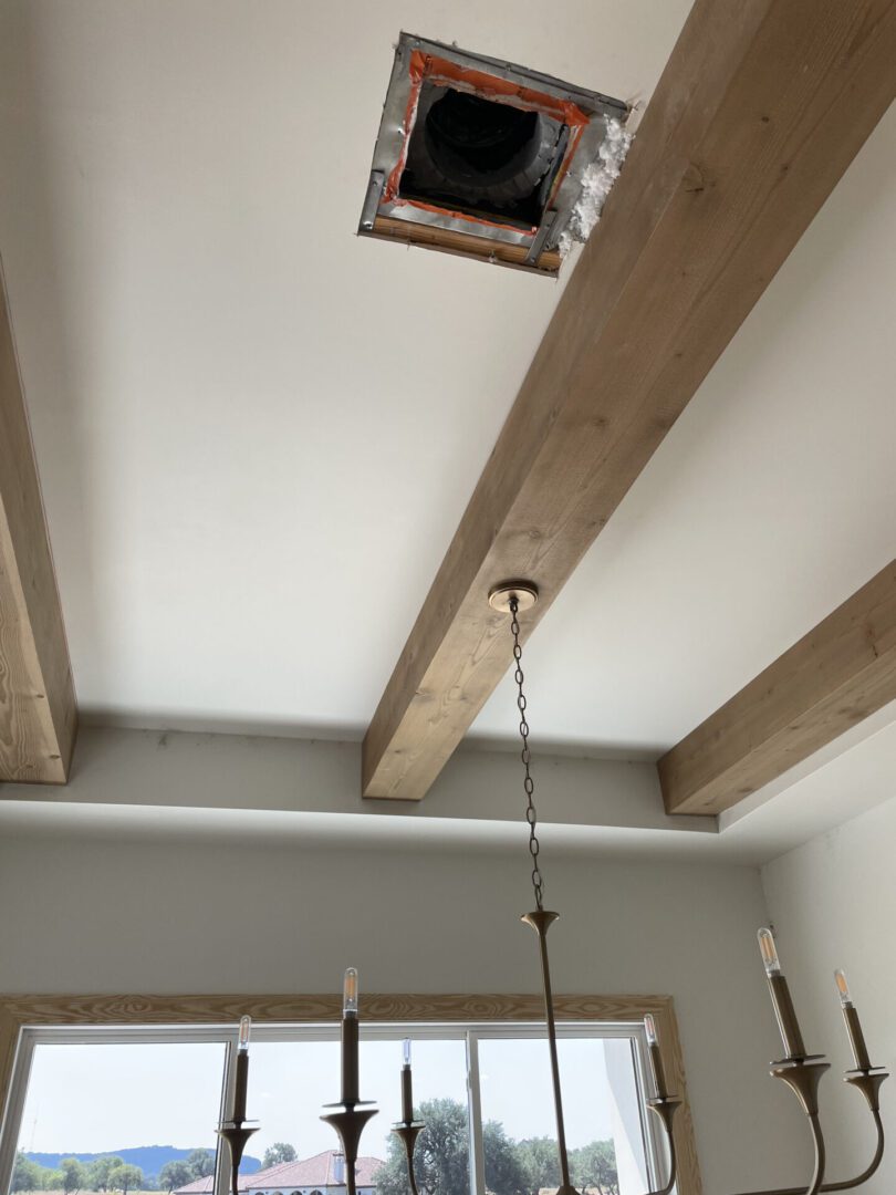 Ceiling with beams and open vent hole.