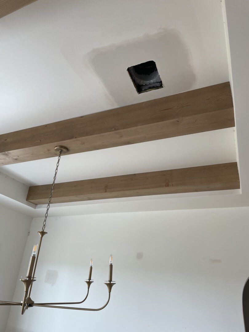 Ceiling with wooden beams and chandelier.