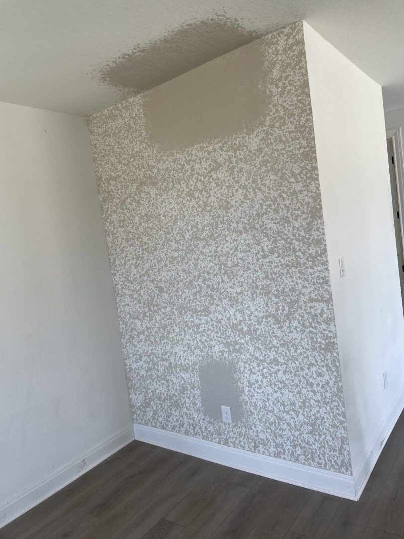 Textured wall corner with paint patches.