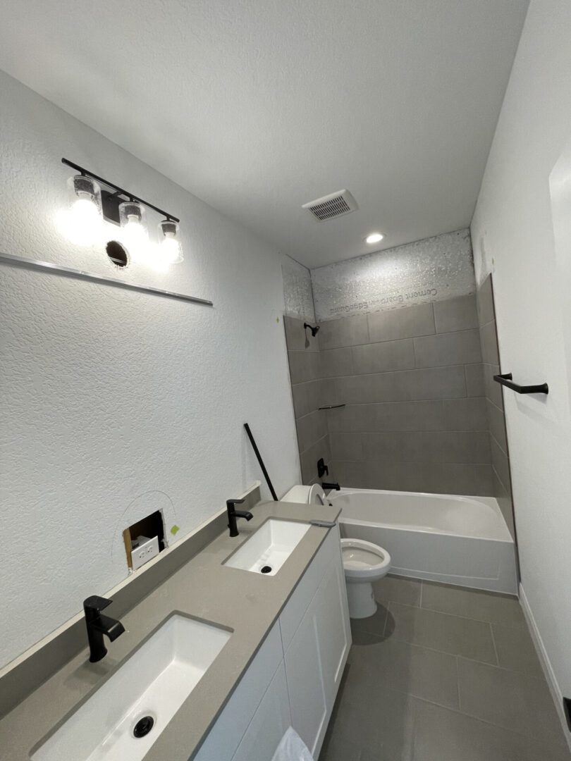 Modern bathroom with double sinks and bathtub.