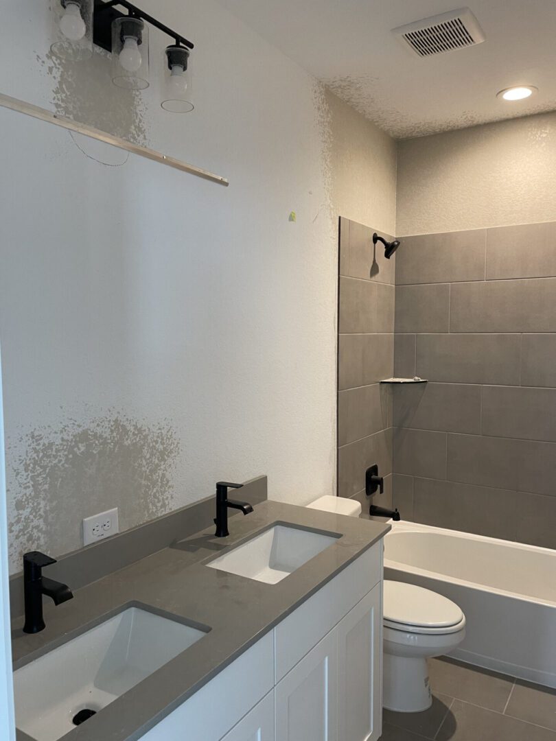 Modern bathroom with gray tiles and fixtures.