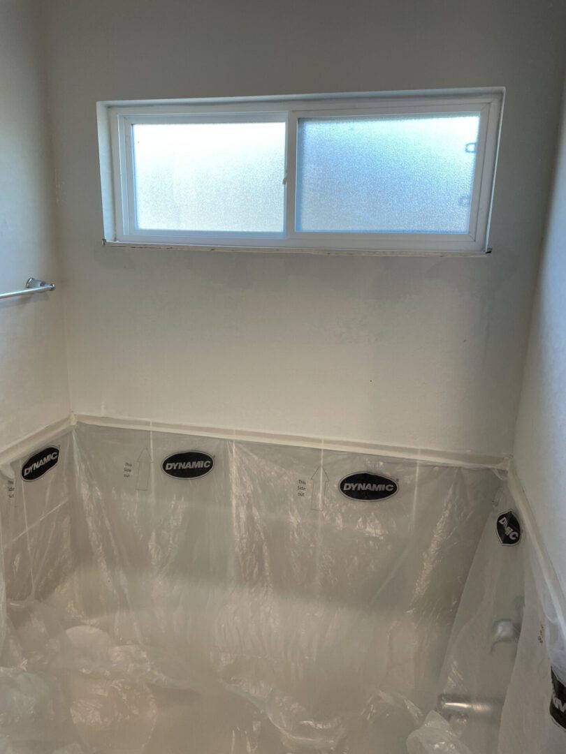 Bathroom renovation with protective plastic sheets.