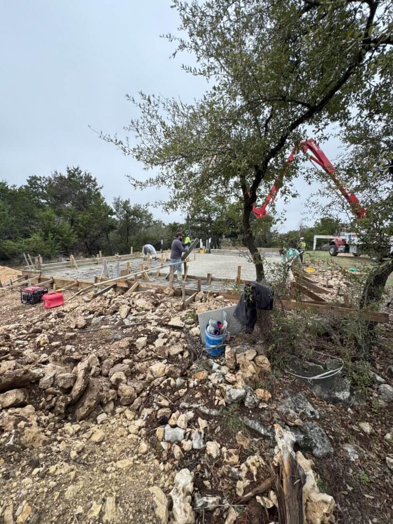 Construction workers pouring concrete at site.